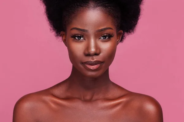 Hermoso retrato de una hermosa modelo afroamericana con hombros desnudos y cabello afro aislado sobre un fondo rosa sucio — Foto de Stock