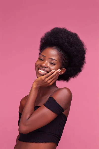 Menina afro-americana encantadora sorrindo tocando sua garota após o tratamento de spa ou rosto. Tratamento spa menina beleza isolado no fundo rosa. Conceito de beleza. — Fotografia de Stock