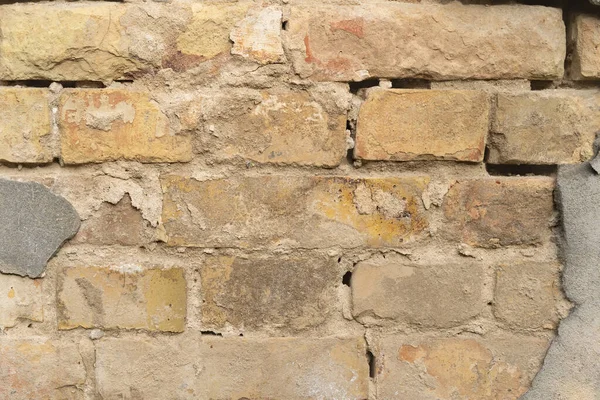 Текстура наружной кирпичной стены со старой облицовкой. Старое здание с падающей штукатуркой. Фон кирпичной стены — стоковое фото