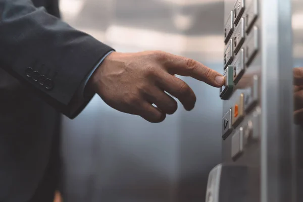 Homem trabalhador de escritório de mão em um terno de negócios pressione o botão do elevador com o dedo. Empresário em um escritório centro elevador interior — Fotografia de Stock