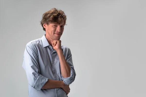 Portrait of a handsome man in blue shirt leaned chin on a fist. Handsome confident caucasian wearing suit standing with crossed arms isolated on white background — Stockfoto