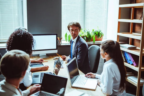 Presentazione del progetto in sala riunioni guardando i colleghi dello schermo bianco si riuniscono discutono le statistiche finanziarie insieme, i colleghi multirazziali che cooperano lavorando insieme alla riunione dell'ufficio — Foto Stock