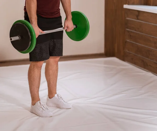 Equipamiento deportivo para entrenamiento. Levantamiento de pesas joven de pie agarró un conjunto de peso negro y verde, equipo para el concepto de entrenamiento con pesas. pérdida de peso, concepto de estilo de vida saludable — Foto de Stock