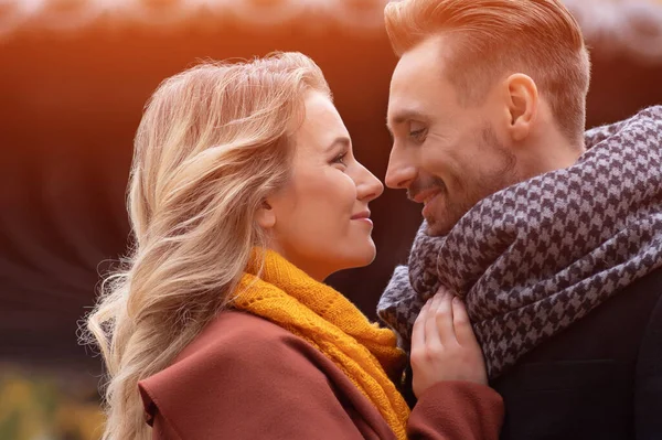 Super close-up de beijar jovem casal. Marido e uma esposa abraçaram o sorriso olhando um para o outro no parque de outono. Tiro ao ar livre de um jovem casal apaixonado — Fotografia de Stock