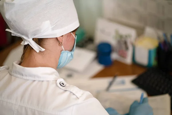 Ung läkare arbetar med patientpapper eller dokument. Läkarteam på oftalmologkontoret. Gammal kvinnlig läkare skriver medicinska blanketter. Stadssjukhuset. Maj 2020, Brovary, Ukraina — Stockfoto
