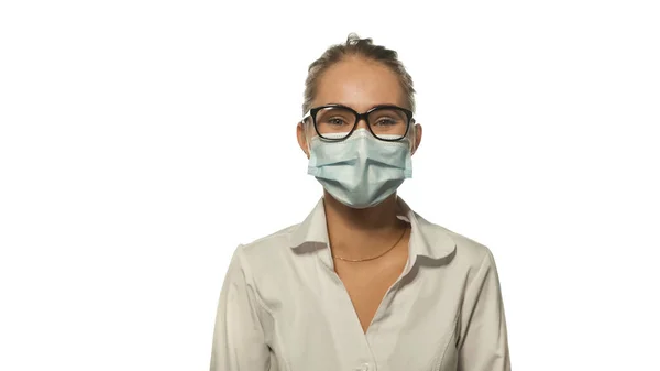 Positivo olhando jovem enfermeira loira em óculos de olho olhando para a câmera vestindo uniforme médico branco isolado no fundo branco — Fotografia de Stock