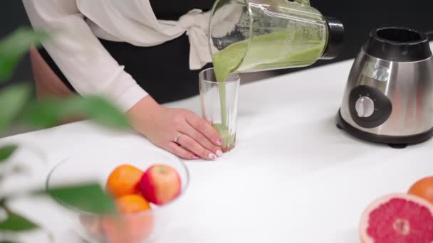Наливаємо в склянку свіжий огірок або авокадо для здорової гладкої молодої жінки з пишним тілом, використовуючи блендер на сучасній кухні. Концепція дієти та харчування. Близько. ФГД — стокове відео