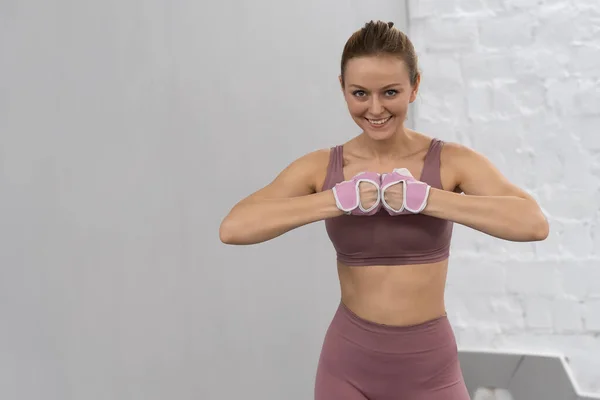 Aquecer os braços em luvas de treinamento de proteção jovem mulher se exercitando em casa com roupas rosa. Esporte e conceito de recreação. Menina Pensiva está desfrutando com seu processo de treinamento trabalhando duro — Fotografia de Stock