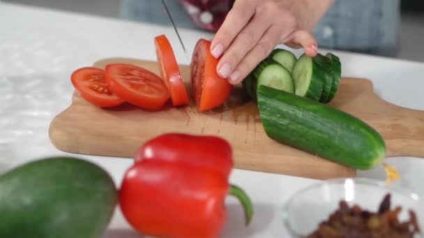 Κόβοντας υλικά φρέσκες ντομάτες και αγγούρι με άλλα συστατικά στο τραπέζι μαγειρεύοντας μια σαλάτα στην κουζίνα. Υγιεινή διατροφή. Υγιεινός τρόπος ζωής Κλείσε. FHD footag — Αρχείο Βίντεο