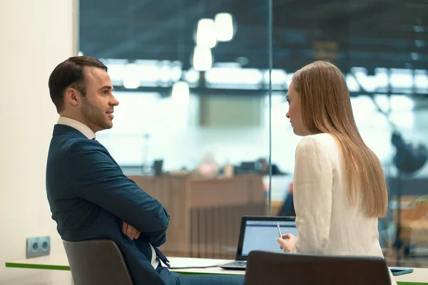 Intervjua en vacker flicka. Närbild av två affärsmän som sitter på arbetsplatsen med dokument på bordet. Framgångsrik intervju med arbetsledare och medarbetare — Stockfoto