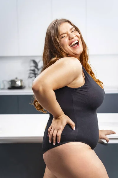 Jeune femme grosse essayant le régime. Fille debout à côté de la table de cuisine. Régime alimentaire jeune femme grosse debout sur la cuisine. Gros plan chubby femelle abaissant le poids de l'IMC. Essayer de perdre du poids rapidement — Photo