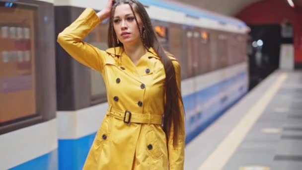 Gik glip af hendes tog rørende hoved smuk ung pige med lange ben i en gul fjeder frakke og en hvid håndtaske følge i bevægelse toget. Optagelser af høj kvalitet. Kyiv Metro – Stock-video