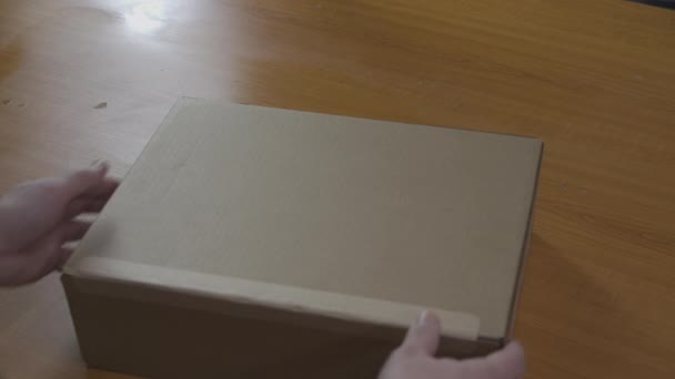 Unboxing Apple MacBook Pro laptop uit doos. De man rukt de beschermende tape van de doos die per post in de bestelling is ontvangen eraf. Geluid inbegrepen. Kiev, Oekraïne, februari 2021 — Stockvideo