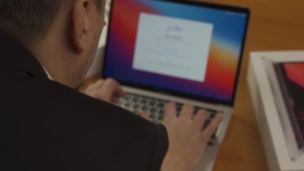 Proprietario che installa un laptop Apple MacBook Pro 13 M1. Nuovo computer portatile MacBook Pro alla fine del 2020 con display Retina IPS a colori True Tone, LED, touch bar, tipo USB C. Con il suono. Concentrazione selettiva sull'uomo. Kiev — Video Stock