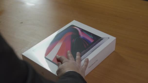 Unboxing Apple MacBook Pro M1 bärbar dator. Händerna öppna laptop och ta ett lock från början. Han sliter av skyddstejpen. Nätköpskoncept. Ljud inkluderat. Kiev, Ukraina, februari — Stockvideo