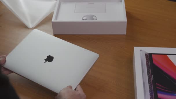 Déboxer un nouvel ordinateur portable Apple MacBook Pro 13 M1 Late 2020 de l'emballage. Les mains ouvertes ordinateur portable et prendre un couvercle à partir de tout son démarrage. Concept d'achat en ligne.Avec son. Kiev, Ukraine, février 2021 — Video