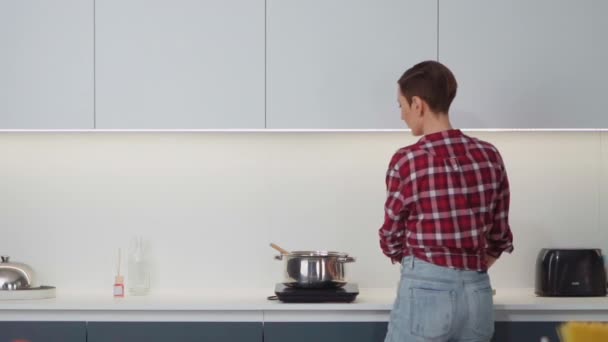 Interferes while dancing while cooking at her new home happy woman. Young woman cooking a lunch standing in the kitchen. Healthy food living. Healthy lifestyle. New home concept — Stock Video