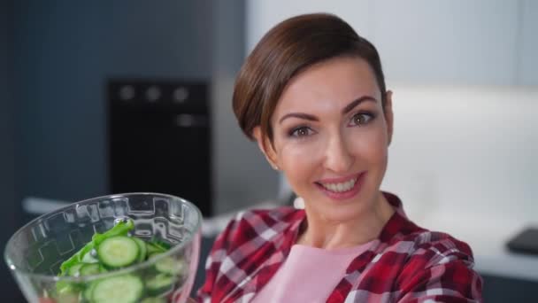 Fecha. Mulher com um bawl de salada de legumes corte de tomate, pepino, pimenta para um jantar de família ou noite de meninas em pé na cozinha. Comida saudável a viver. Estilo de vida saudável. Imagens de FHD — Vídeo de Stock