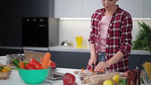 Cortar cenoura fresca na mesa cozinhar um almoço ou jantar de pé na cozinha. Comida saudável a viver. Estilo de vida saudável. Fecha. Imagens de FHD Vídeo De Bancos De Imagens