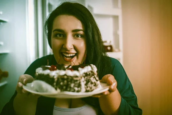 Plus Size modello sorrisi Holding piatto con torta al cioccolato — Foto Stock