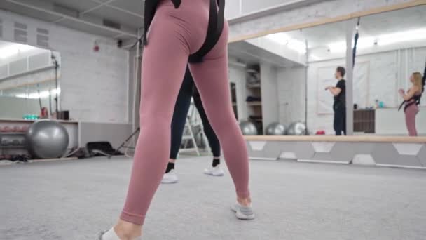 Beautiful girls are engaged in improving their beautiful figure. Beautiful video about classes in gym with a trainer. — Stock Video