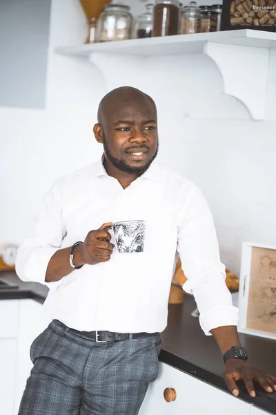 Hem tröst. afro amerikansk make med en kopp stå för i köket efter jobbet — Stockfoto