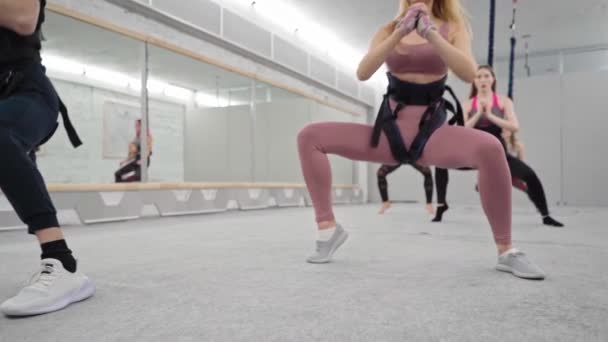 Bungee fitness klass grupp av friska kvinnor stretching förbereda sig för morgon verk öva poser njuter hälsosam livsstil utbildning i fitness studio — Stockvideo