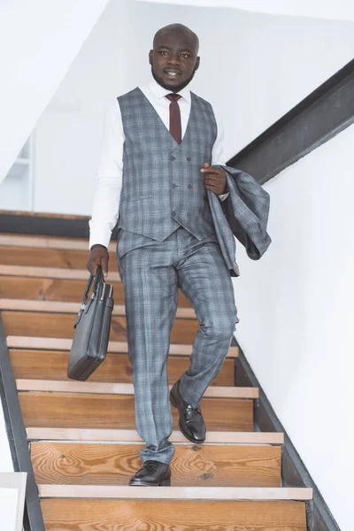 Erfolgreicher Jungunternehmer. Afroamerikaner steigt morgens Treppen zur Arbeit hinab. Konzept des luxuriösen, reichen Lebens. Hochwertiges Foto — Stockfoto