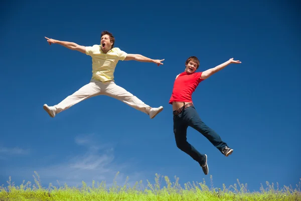 Young people jump on hill in park — Stock Photo, Image