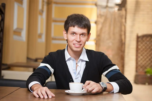 ชายหนุ่มข้ามโต๊ะกับถ้วยกาแฟ — ภาพถ่ายสต็อก