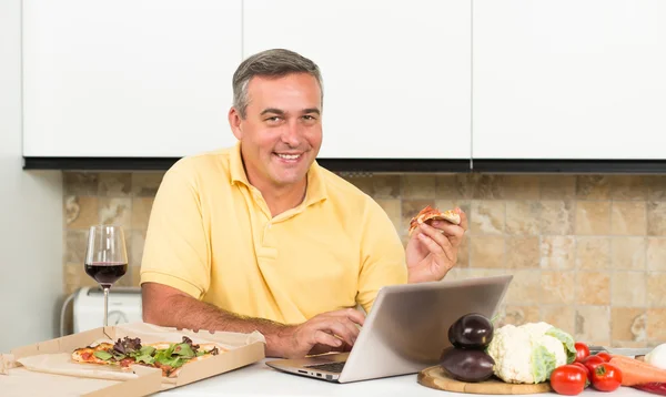 Hombre maduro con portátil en la cocina — Foto de Stock