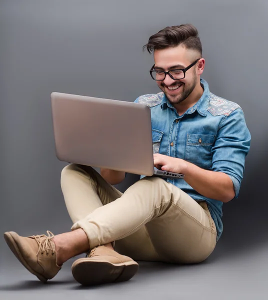Yakışıklı hipster adam dizüstü bilgisayar ile — Stok fotoğraf