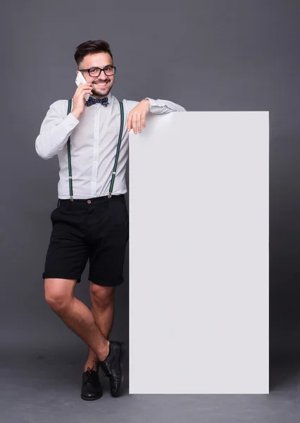 Hipster homem posando com cartaz em branco — Fotografia de Stock