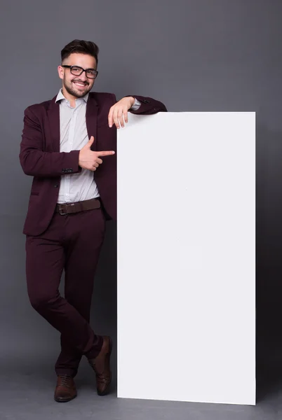 Hipster hombre en traje de negocios con cartel en blanco —  Fotos de Stock