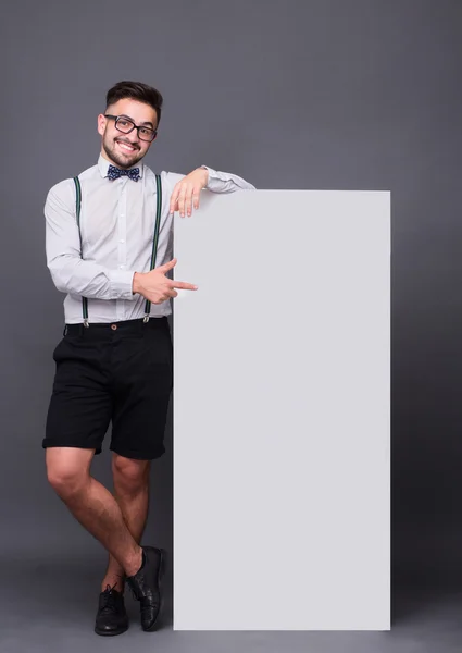 Hipster homem posando com cartaz em branco — Fotografia de Stock