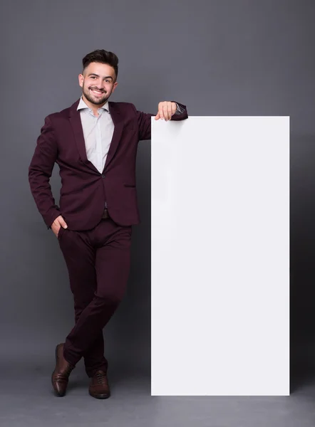 Hipster man in business suit with blank poster — Stockfoto
