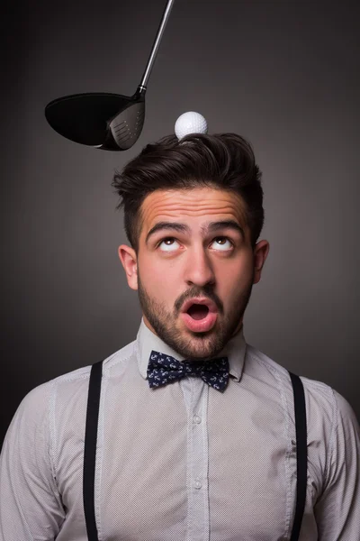 Handsome man with a golf ballon his head in studio — Stock Photo, Image