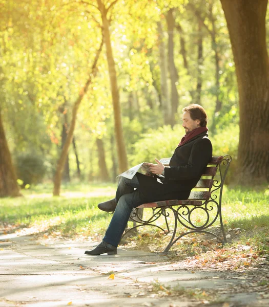 Uomo che legge il giornale nel parco — Foto Stock