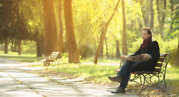 Man reading newpaper in the park — Stockfoto