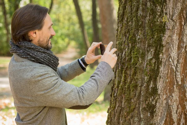 Schöner Mann mittleren Alters macht Fotos im Park — Stockfoto