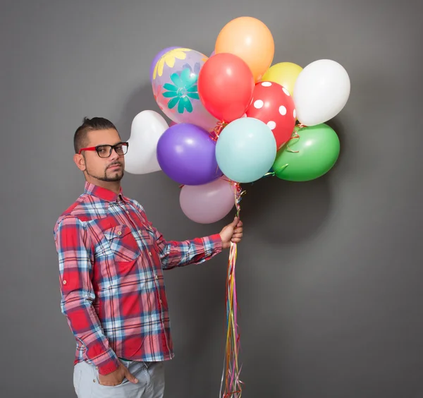 Vacker hipster man med flerfärgad baloons i studio — Stockfoto