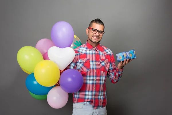 Bello hipster uomo con palloncini multicolori in studio — Foto Stock