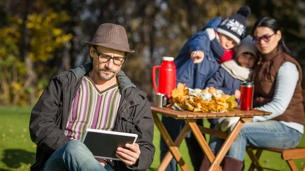 Father working on a picnic with his tablet PC — Stock Fotó