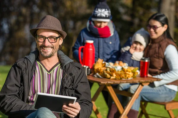 Father working on a picnic with his tablet PC — Stock Fotó