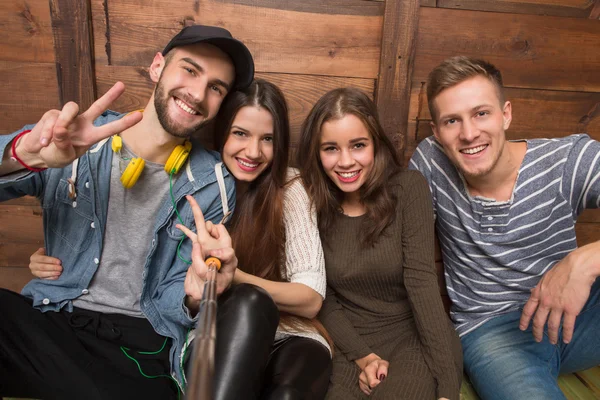 Amigos felizes sentados no chão e sorrindo — Fotografia de Stock