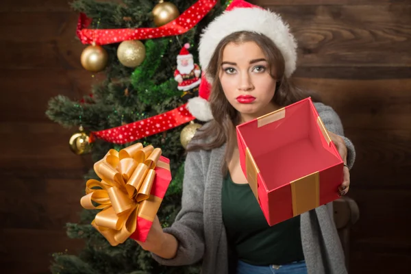 Beautiful girl demonstrating empty box of present near New Year tree — Stock Photo, Image