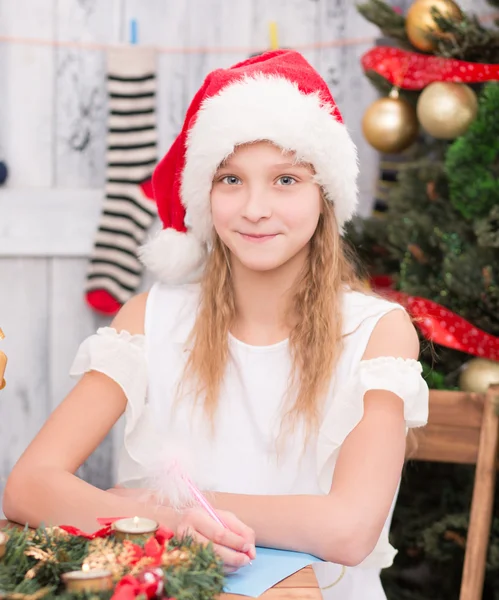 Happy girl sitting at the table — Stock Photo, Image