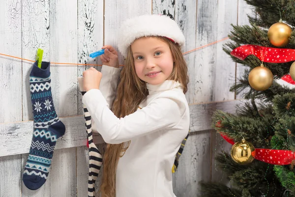 Teenage girl looking into Christmas socks — ストック写真