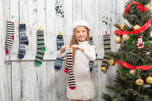 Teenage girl looking into and Christmas socks — Stock Photo, Image