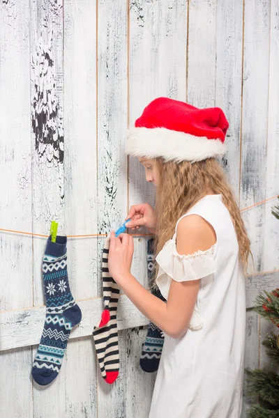 Teenage girl looking into Christmas socks — ストック写真